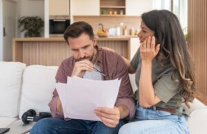couple looking at papers on couch in living room