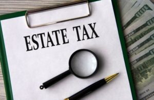 estate tax written on clipboard with pen and magnifying glass