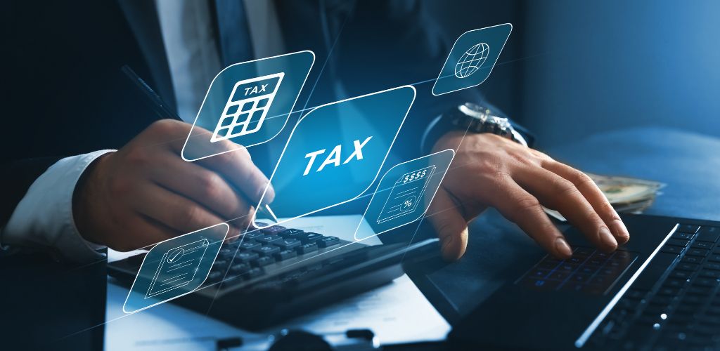 stylized image of man typing on computer as animated tax graphics float