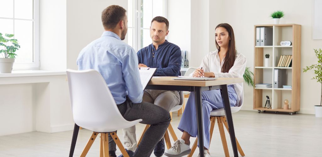irritated couple of clients at table with a man