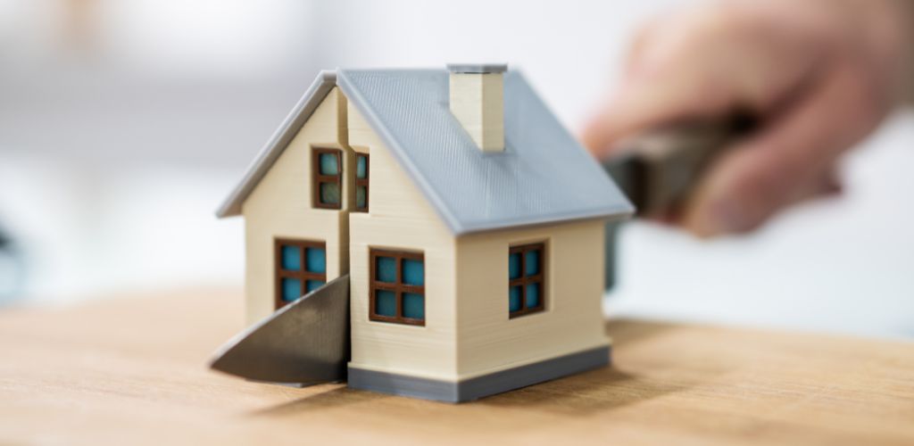 model house getting cut in half by knife
