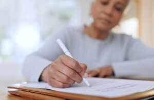 older woman signing paper