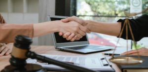 two people shaking hands across a desk