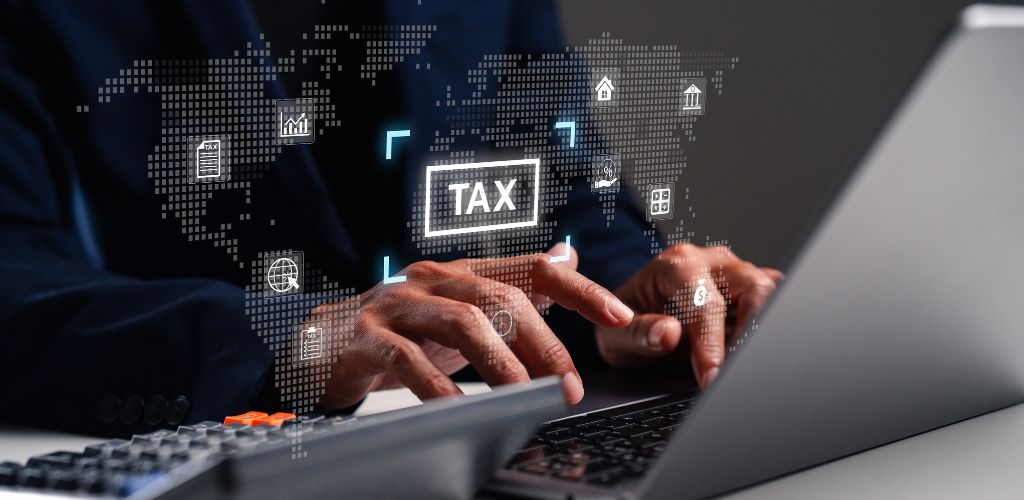 man at laptop with illustrative "tax" icon floating