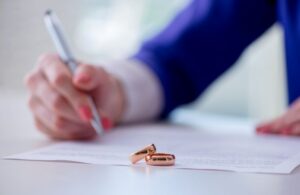 woman signing prenuptial agreement