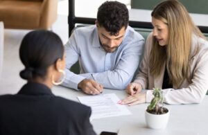 young couple signing prenuptial agreement